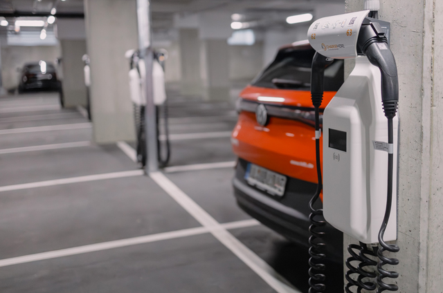 An electric car is charged via a charging point in a parking garage.